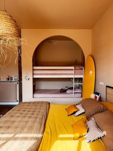 a bedroom with a large yellow bed with an archway at La Casita in Mimizan