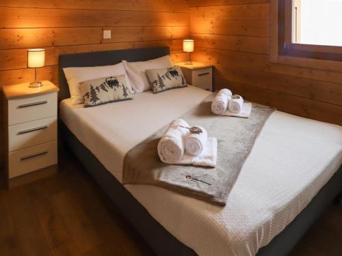 a bedroom with a bed with towels on it at Chalet Le Grillon by Interhome in Nendaz