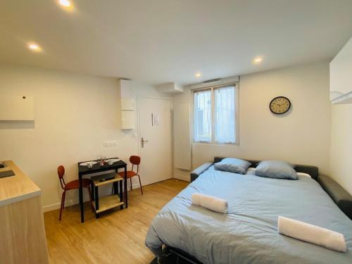 - une chambre avec un lit, une table et une horloge dans l'établissement Casa Jacques, à Angers