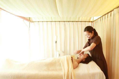 a woman is washing a woman on a bed at Suimeikan in Gero