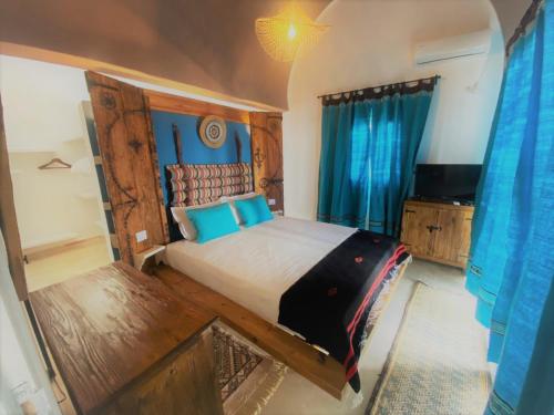 Hôtel Djerba Authentique - Au centre de Midoun في ميدون: غرفة نوم بسرير كبير وتلفزيون