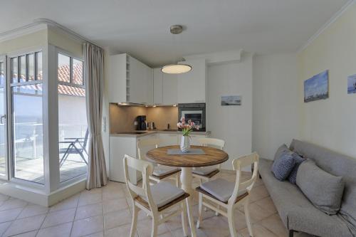 a living room with a table and chairs and a kitchen at Strandhaus Brunhild in Timmendorfer Strand