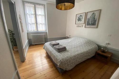 une chambre avec un lit et un parquet dans l'établissement Le Grilleton, à Dole