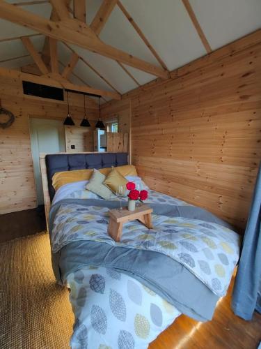 a bedroom with a bed with a table on it at Riverside cabin in Limerick