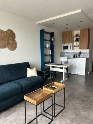 un salon avec un canapé bleu et une table dans l'établissement Studio vue mer Nouveau!, à Anglet