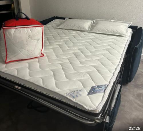 - un lit avec des draps blancs au-dessus dans l'établissement Studio vue mer Nouveau!, à Anglet