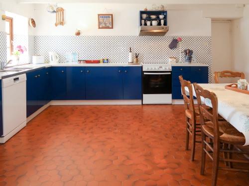 une cuisine avec des placards bleus et une table avec des chaises dans l'établissement Holiday Home Ker Iliav by Interhome, à Plouescat