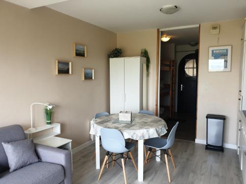 un salon avec une table, des chaises et un canapé dans l'établissement studio Vue sur baie, à Wimereux