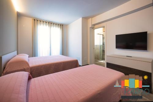 a hotel room with two beds and a flat screen tv at Al Parco in Rosolina Mare