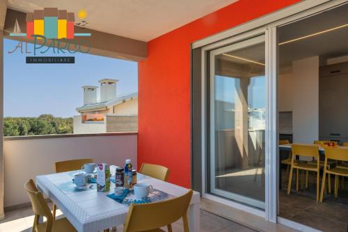 a dining room with a table and chairs and a balcony at Al Parco in Rosolina Mare