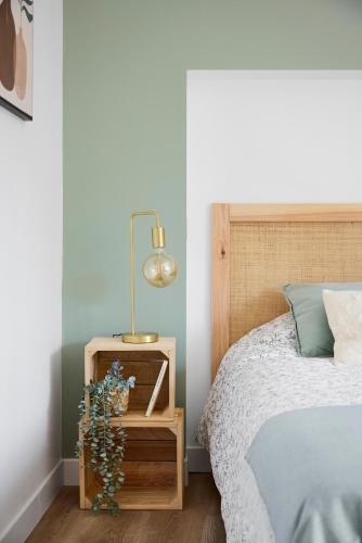 a bedroom with a bed and a lamp on a night stand at Le Duplex in Saint-Nicolas-de-Redon