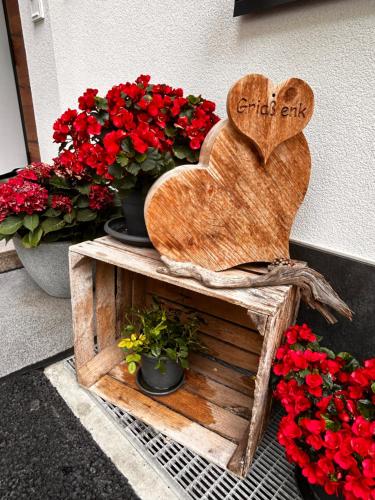 a wooden heart sitting on a table next to flowers at Augl‘s Hof in Ischgl
