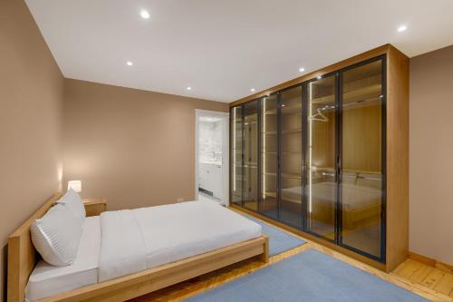 a bedroom with a white bed and a glass wall at VESTA - Nile View Residence in Cairo