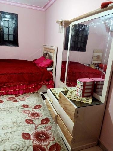 a bedroom with a red bed and a mirror at Big pyramid view in Cairo