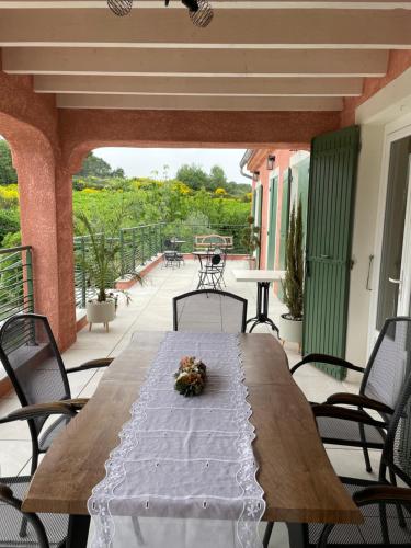 - une table en bois sur un balcon avec des chaises et une table dans l'établissement Casa de Lyu, à Mirabel-aux-Baronnies