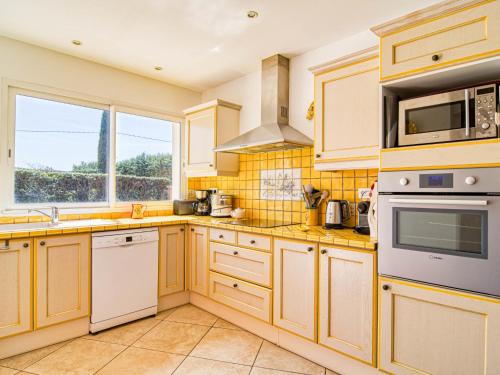 - une cuisine avec des placards en bois et des appareils blancs dans l'établissement Holiday Home Villa Faro by Interhome, à Montfort-sur-Argens