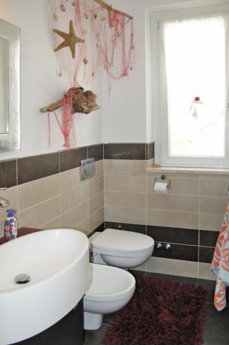 a bathroom with a sink and a toilet and a window at Apartment Ulivi sul Mare by Interhome in Poggi