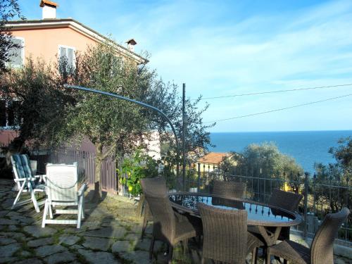 a patio with a table and chairs and the ocean at Apartment Ulivi sul Mare by Interhome in Poggi