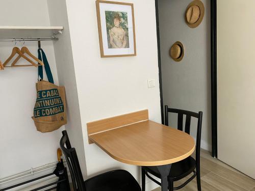 une petite table et des chaises dans une chambre dans l'établissement Cosy studio, à Paris