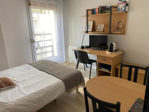 une chambre avec un lit et un bureau avec un ordinateur dans l'établissement Cosy studio, à Paris