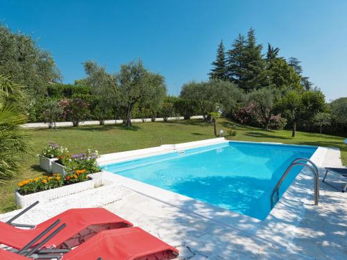 a swimming pool with a table and two chairs next to it at Holiday Home Incantevole by Interhome in Soiano del Lago