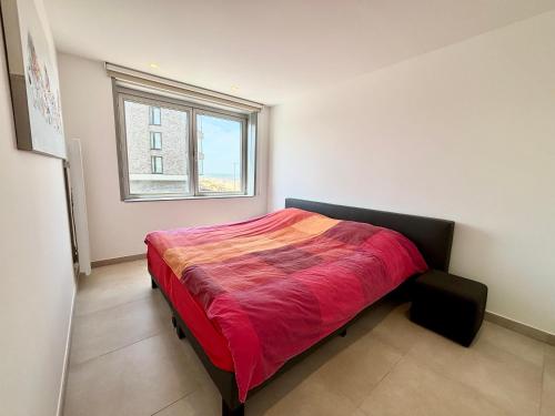 科克赛德La Croisette 0102的一间卧室配有一张带红色棉被的床和窗户。