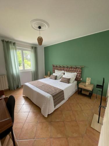 une chambre avec un grand lit aux murs verts dans l'établissement Casa de Lyu, à Mirabel-aux-Baronnies