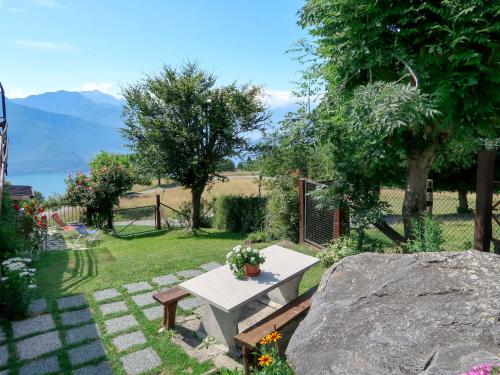 a garden with a bench and a table with flowers at Apartment Mia e Giulia by Interhome in Dosso del Liro