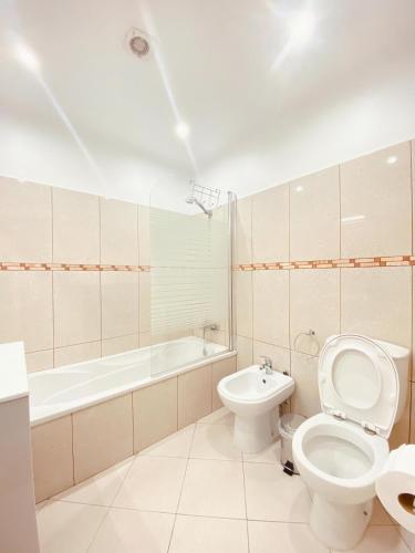 a bathroom with a toilet and a bath tub at Village Square Coastal Apartment 3G in Machico