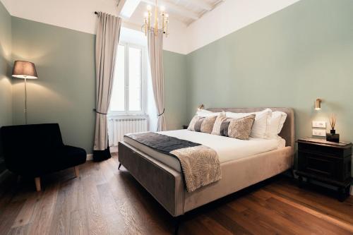 a bedroom with a bed and a chair and a window at NAMAN HOTELLERIE - Monti in Rome
