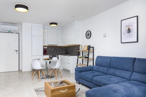 Una sala de estar con un sofá azul y una cocina. en Relax Trogir, en Trogir