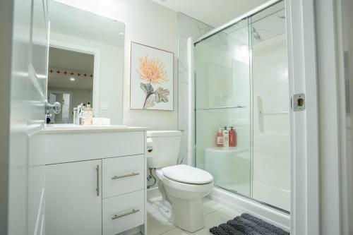 a white bathroom with a toilet and a shower at Warm getaway Perfect for 4 in Edmonton