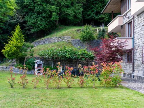 einen Garten mit einer Felswand mit Blumen und Pflanzen in der Unterkunft Holiday Home Salice Verde - GLA134 by Interhome in Gera Lario
