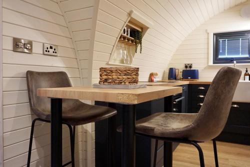 a kitchen with a table and two chairs at EASTRIDGE GLAMPING in Shrewsbury