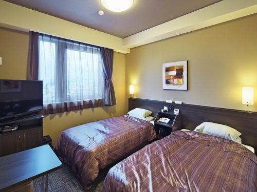Tempat tidur dalam kamar di Hotel Route-inn Yaita