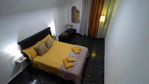 a bedroom with a bed with yellow sheets and pillows at CASA MARY, Céntrico y amplio piso cerca del mar, en Candelaria in Candelaria