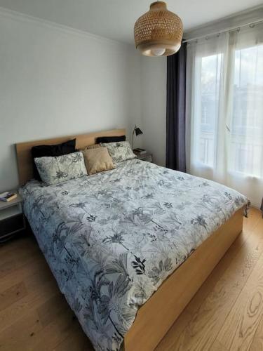 une chambre avec un lit avec une couette bleue et une fenêtre dans l'établissement Appartement Versailles, à Versailles