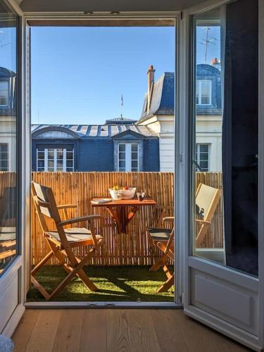 un patio avec une table et des chaises sur un balcon dans l'établissement Appartement Versailles, à Versailles