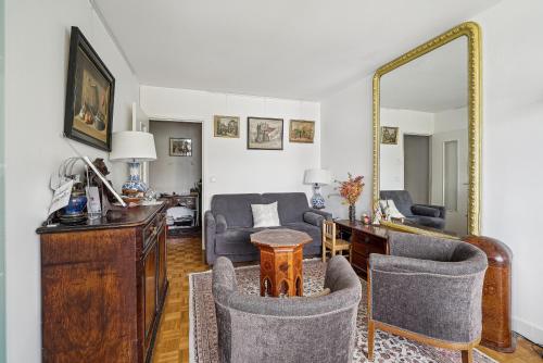 - un salon avec une table, des chaises et un miroir dans l'établissement Appartement de charme dans le Saint-Lambert by Weekome, à Paris