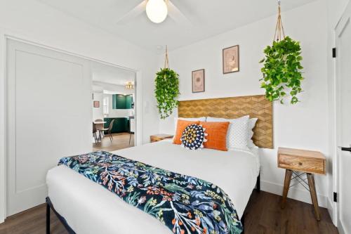 ein Schlafzimmer mit einem großen weißen Bett mit orangefarbenen Kissen in der Unterkunft North Park Boho Bungalow by Rather Be Properties in San Diego