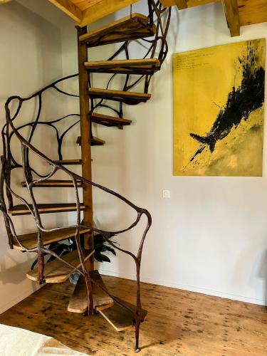 a metal spiral staircase in a room with a painting at Château d'Aigneville in Aigneville