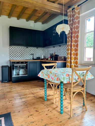 a kitchen with blue cabinets and a table and chairs at Château d'Aigneville in Aigneville