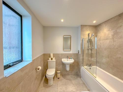 a bathroom with a toilet and a sink and a shower at Baker Street Apartments in London
