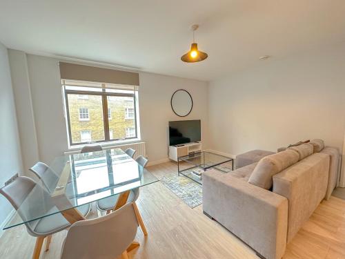a living room with a glass table and a couch at Baker Street Apartments in London