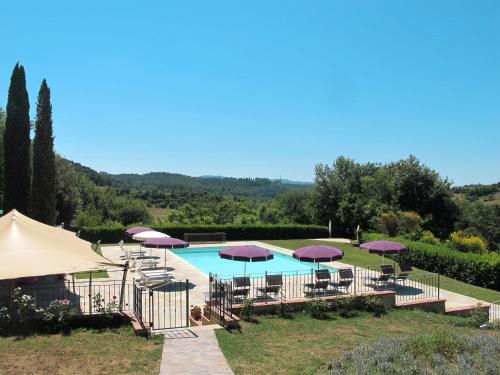 a swimming pool with purple umbrellas and chairs at Holiday Home Antico Borgo San Lorenzo by Interhome in Poggibonsi