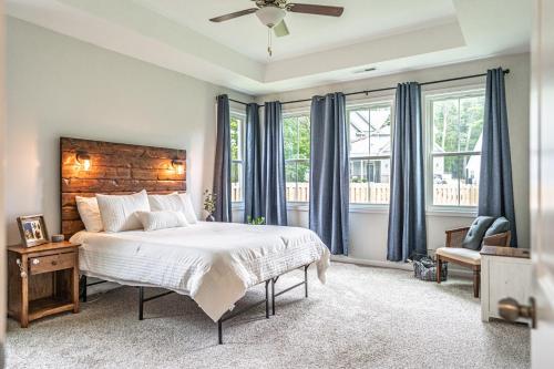 a bedroom with a large bed with blue curtains at The Clubhouse Retreat on Glasgow in Aberdeen