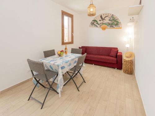 a living room with a table and chairs with a red couch at Home BellaVista, a pochi passi dalla spiaggia in Favignana