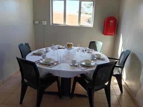 a dining room table with a white tablecloth and chairs at Mabhida Guesthouse in Durban
