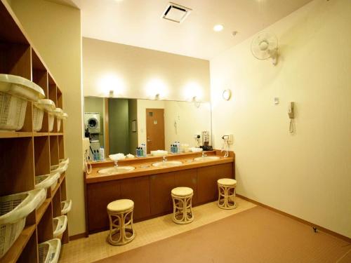 a bathroom with two sinks and a large mirror at Hotel Route-Inn Hamanako in Kosai