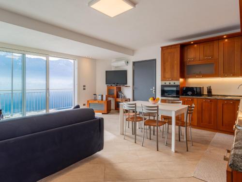 ein Wohnzimmer mit einer Couch und einem Tisch mit Stühlen in der Unterkunft Apartment Girasole - GLA128 by Interhome in Gera Lario